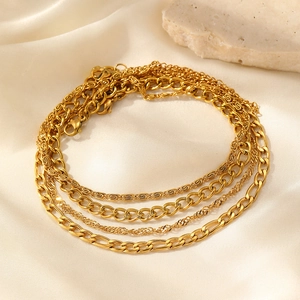 Detailed macro view of four gold chain anklets including figaro and rope link styles