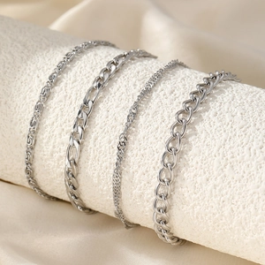 Set of four stylish silver chain anklets featuring figaro and curb links for a beach look