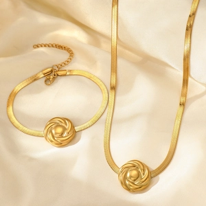 Parure dorée maille serpent avec motifs de roses sur fond de soie couleur champagne