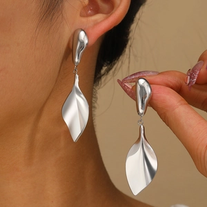 Detail of silver geometric fringe earrings in a minimalist liquid metal design on model