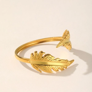 Detailed view of the gold-plated stainless steel feather ring with adjustable open band