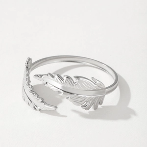Adjustable silver feather ring in stainless steel with detailed texture on white background