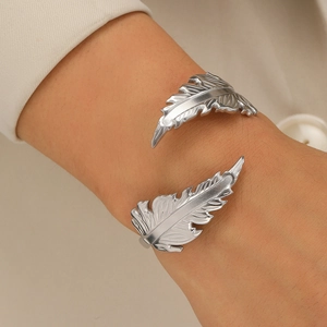 Close-up of adjustable stainless steel feather ring with detailed silver texture on hand