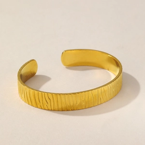 Detailed view of the 18K gold plated cuff bracelet featuring a unique vertical wavy texture