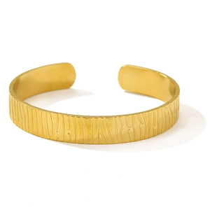 Detailed close-up of C-shaped open bangle with unique bionic wood grain texture in 18K gold