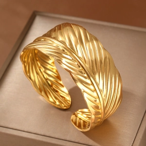 Adjustable golden feather cuff bracelet in brushed stainless steel with boho texture