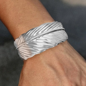 Adjustable stainless steel feather cuff bracelet with detailed texture and silver finish