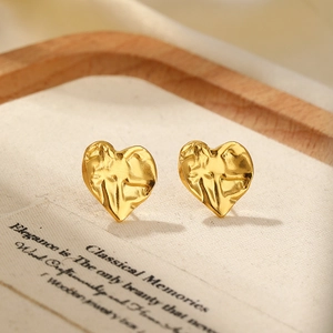 Close-up of heart-shaped gold earrings with vintage French rippled texture detail