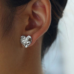 Macro shot of a silver heart stud earring with unique vintage wrinkled water ripple texture