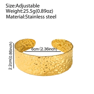 Macro-opname van de gouden roestvrijstalen open armband met unieke gehamerde textuur