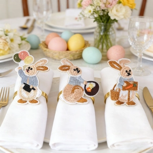 Detailed view of Easter embroidered rabbit napkin rings with golden metal holders