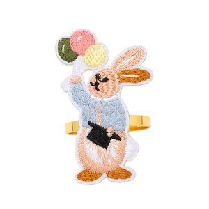 Embroidered rabbit napkin ring with blue coat and golden metal loop for table decor
