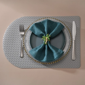 Tropical coconut tree napkin ring with green enamel and pearls on dark teal fabric