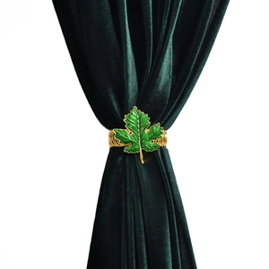 Détail d'embrasse de rideau en feuille d'érable verte avec bande ressort dorée