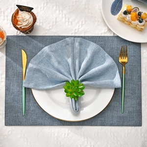 Detail of green succulent napkin ring with light blue linen cloth on a rectangle placemat