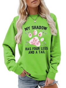 Dettaglio della felpa verde con stampa della zampa e slogan my shadow has four legs