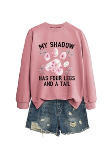 Dettaglio felpa rosa con testo 'MY SHADOW HAS FOUR LEGS' e stampa zampa floreale