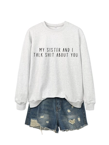Detail view of light gray crewneck sweatshirt with black bold text and denim shorts