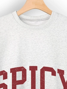 Detail of red SPICY distressed lettering on a light grey casual sweatshirt