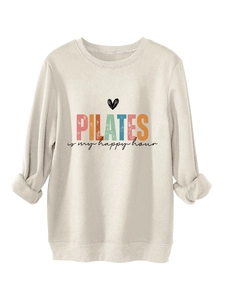 Dettaglio della stampa Pilates su felpa beige spessa con polsini a costine e morbido pile