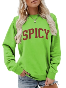 Detail of loose-fit green crewneck sweatshirt with red SPICY lettering and ribbed cuffs