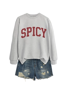 Detail of grey SPICY sweatshirt and distressed denim shorts with frayed edges