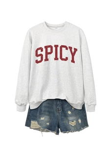 Detail of light grey crewneck sweatshirt with red SPICY print and frayed denim shorts