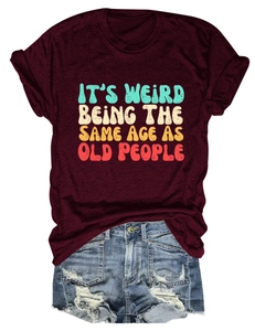 Close-up of wine red t-shirt with slogan and ripped denim shorts for summer