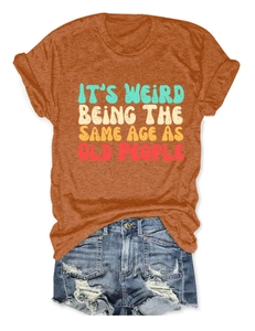 Detail of orange cotton T-shirt with retro slogan paired with frayed denim shorts