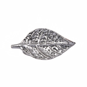 Macro detail of antique silver leaf napkin ring with intricate vein textures and retro finish