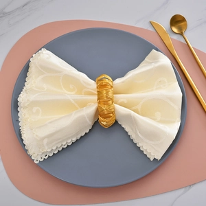 Rond de serviette en métal doré tissé élégant sur serviette en dentelle blanche