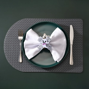 Close-up of Halloween ghost napkin ring with purple bow on white fabric napkin