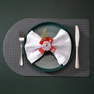 Detail of Christmas napkin ring featuring Santa Claus and red ribbon on a white napkin