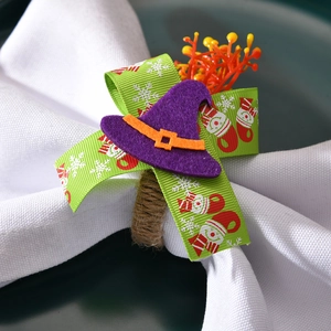 Macro view of woven napkin ring featuring purple felt witch hat and festive holiday ribbon