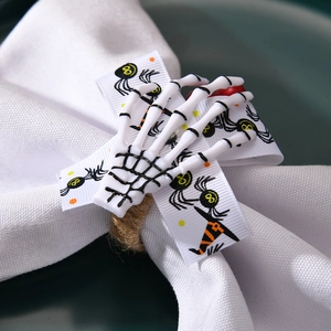 Macro shot of Halloween skeleton hand napkin ring with spider ribbon and natural hemp rope