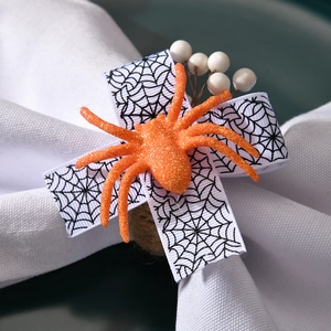 Detail of orange glitter spider napkin ring with web ribbon and rustic twine