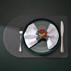 Close-up of Halloween napkin ring with spider web and bat on a dark green plate
