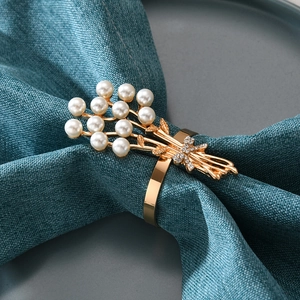 Eleganter goldener Perlen-Serviettenring mit Strass auf blauer Stoffserviette