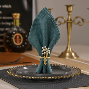 Eleganter Rosen-Serviettenring mit Perlen und Strass auf grauem Teller für Tischdeko
