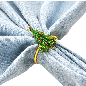 Christmas cedar napkin ring with red rhinestones and green enamel on blue cloth