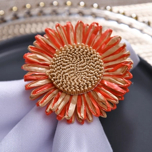 Nahaufnahme des handgewebten Sonnenblumen-Serviettenrings aus Raffia auf einer Leinenserviette