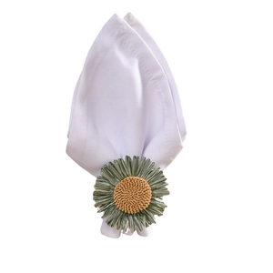 Sonnenblumen-Serviettenring mit grünen Blütenblättern auf weißer Serviette, Draufsicht