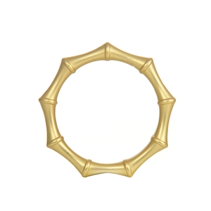 Detail of champagne gold bamboo-shaped napkin ring with matte metallic texture finish