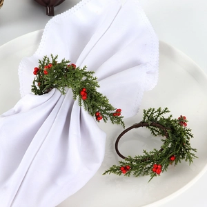 Detail of handmade Christmas napkin rings with red berries and green pine needles decoration