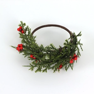 Handmade Christmas napkin ring with green pine needles and red berries on white background