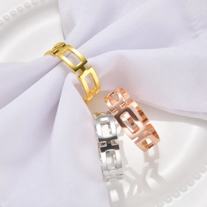 Detailed view of hollow rectangular napkin rings in gold, rose gold, and silver finishes