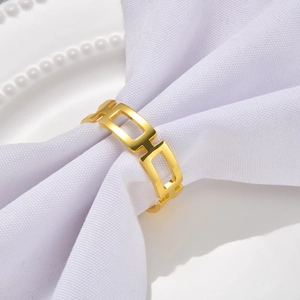 Detailed close-up of a gold hollow geometric square napkin ring on white pearl decor