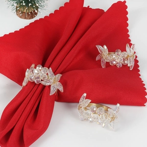 Close-up of golden wire woven napkin rings with crystal beads and leaf ornaments