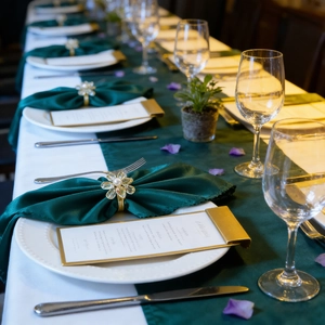 Close-up of golden flower napkin ring with crystal petals and pearl on green fabric