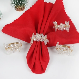 Close-up of sparkling crystal flower napkin rings on red napkins for festive dining decor